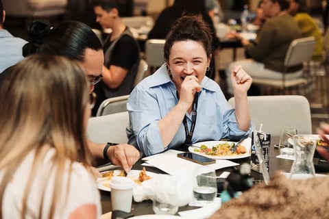 A delegate laughing over lunch at the Māori Leadership Summit 2025