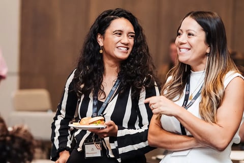 Two delegates laughing together at the Māori Leadership Summit 2025