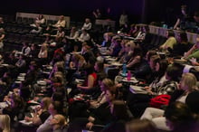 Delegates seated at tables during a session
