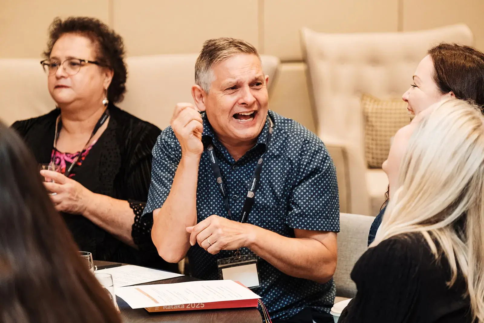 Delegates laughing together at their table at the Māori Leadership Summit 2025