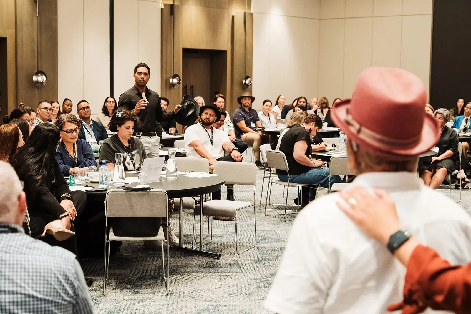 Tāme Iti speaking with delegates seated around him at the Māori Leadership Summit 2025